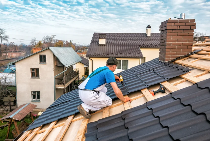 Roofer installing new roofing over exposed decking