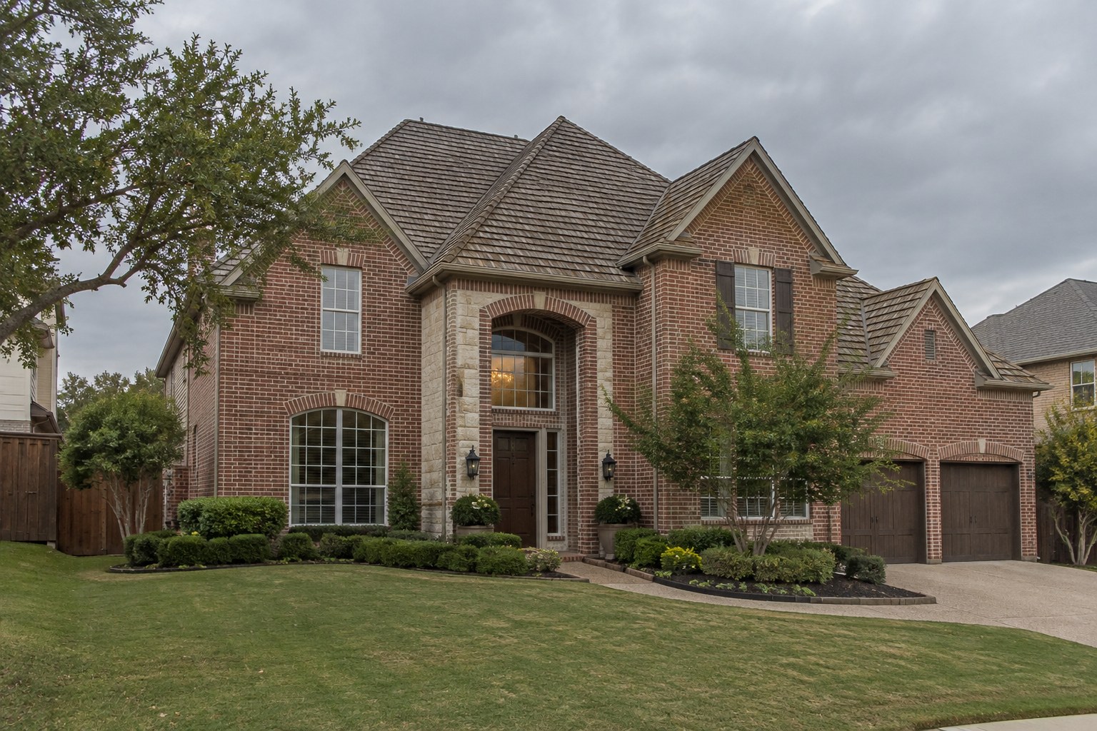 Two-story red brick Allen home with a new weathered wood blended shingle roof