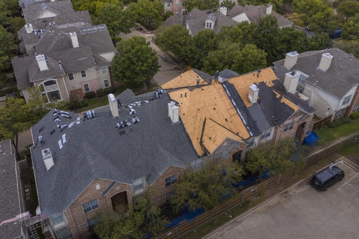 Aerial view of a multi-family residential building undergoing roof replacement in Allen, TX