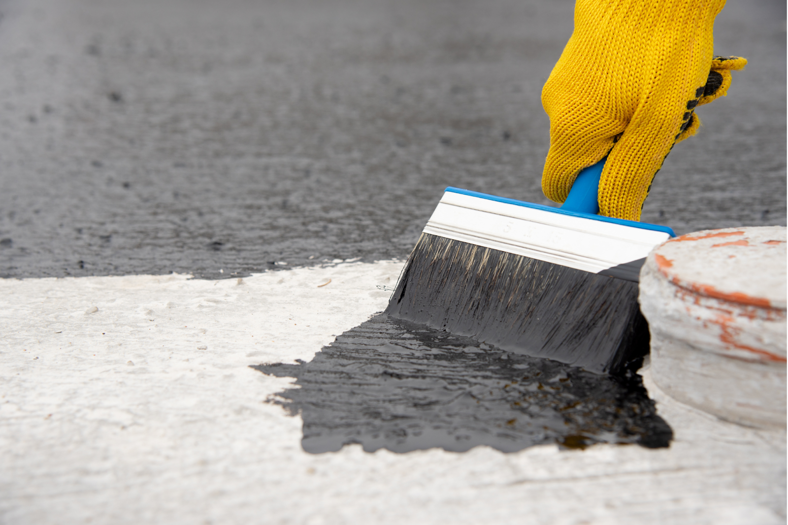 a brush being used for roof coating