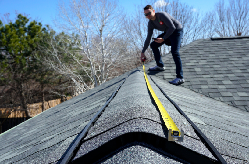 man measuring roof